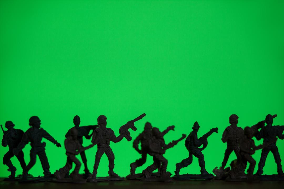 Silhouetted Army Toy Soldiers Against Green Background - Free Images, Stock Photos and Pictures on Pikwizard.com