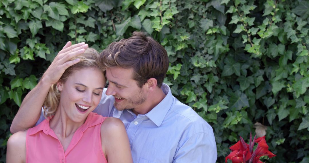 Couple Smiling and Embracing in Front of Greenery - Free Images, Stock Photos and Pictures on Pikwizard.com