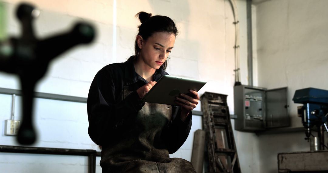 Female Engineer Using Digital Tablet in Workshop Setting - Free Images, Stock Photos and Pictures on Pikwizard.com