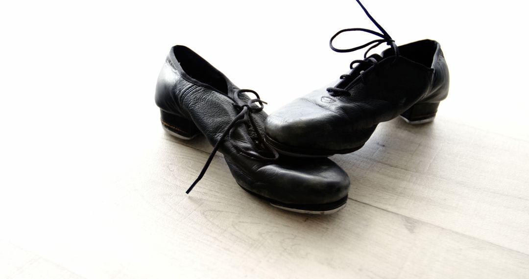 A pair of black tap shoes rests on a wooden floor, with copy space - Free Images, Stock Photos and Pictures on Pikwizard.com