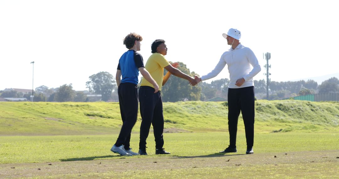 Coach and Players Shaking Hands on Green Field Promoting Team Spirit