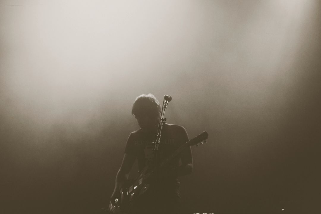 Silhouette of Guitarist Performing on Stage with Moody Lighting - Free Images, Stock Photos and Pictures on Pikwizard.com