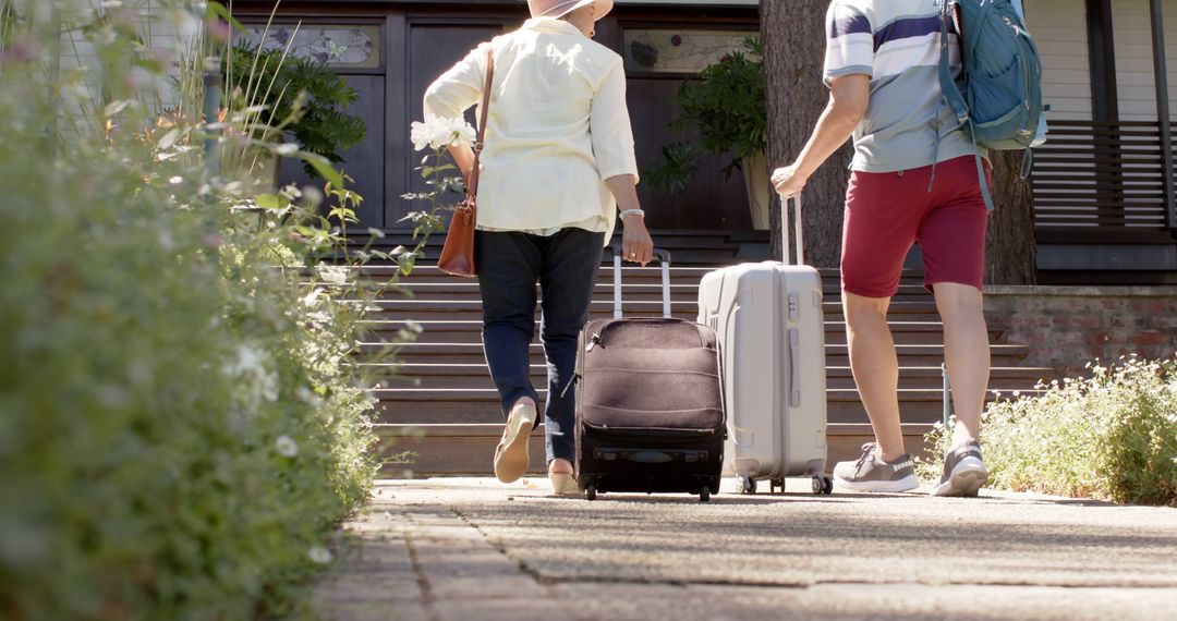 Couple Traveling with Luggage Down Residential Pathway - Free Images, Stock Photos and Pictures on Pikwizard.com