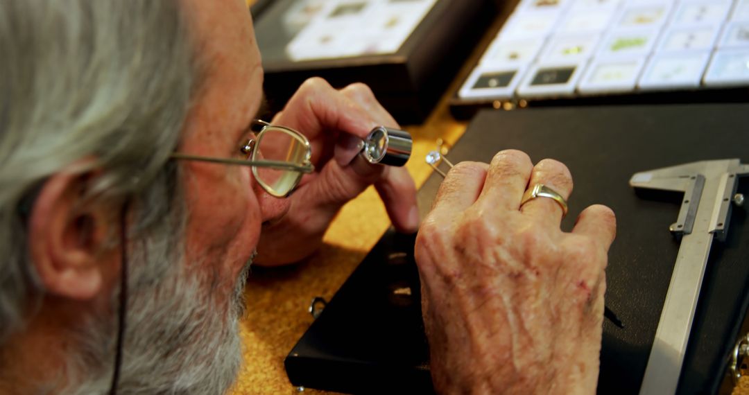 Jeweler Examining Diamond with Magnifying Glass in Workshop - Free Images, Stock Photos and Pictures on Pikwizard.com