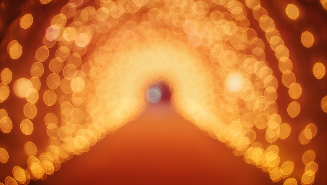 Golden Bokeh Light Tunnel Creating Warm Festive Archway with Soft Blue Focal Point