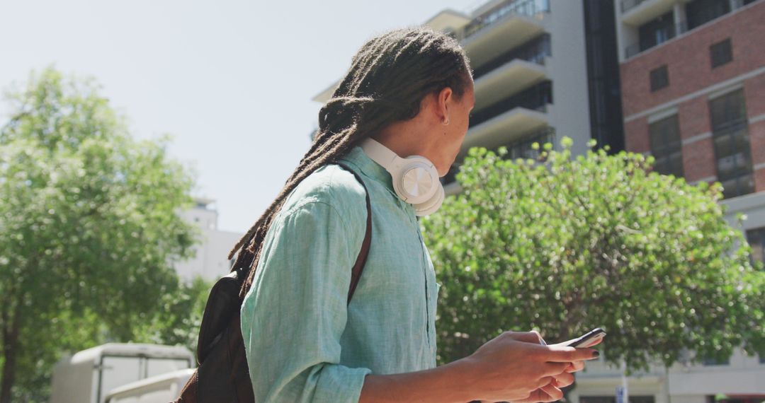 Fashionable biracial man with dreadlocks using smartphone on street - Free Images, Stock Photos and Pictures on Pikwizard.com