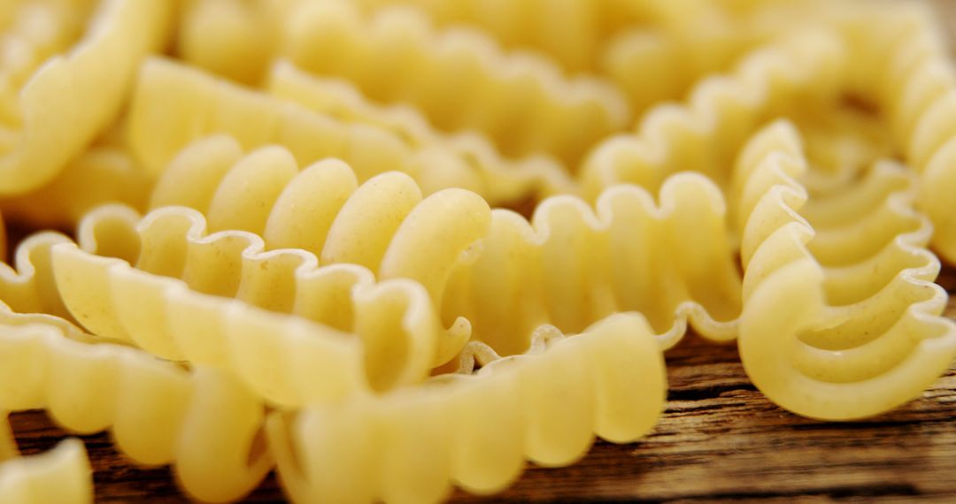 Close-Up of Uncooked Fusilli Pasta on Wooden Surface - Free Images, Stock Photos and Pictures on Pikwizard.com