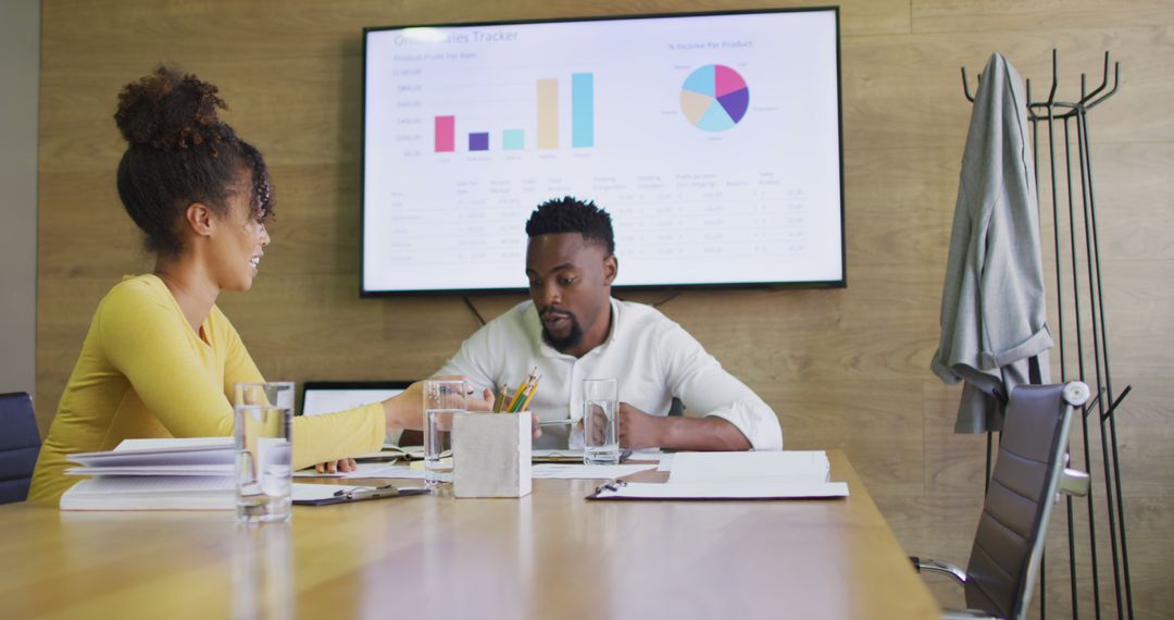 Colleagues Collaborating on Financial Reports in Modern Office