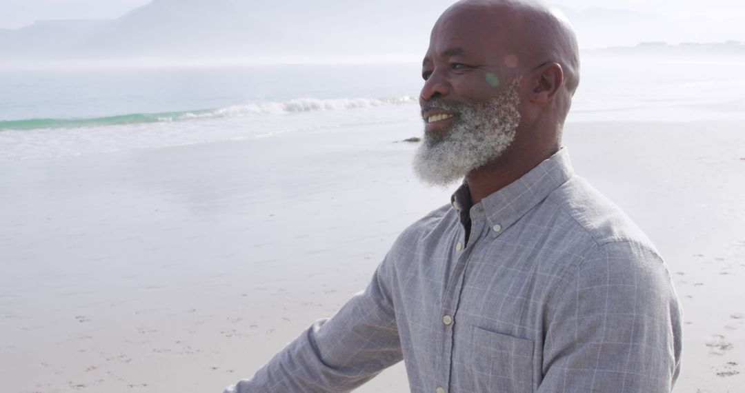 Senior Man Enjoying a Peaceful Stroll on a Misty Beach - Free Images, Stock Photos and Pictures on Pikwizard.com