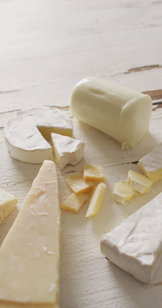 Assorted Gourmet Cheeses on Rustic Wooden Surface