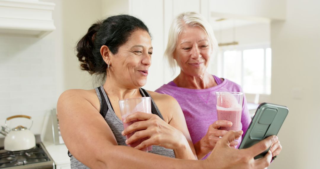 Two Senior Women Drinking Smoothies and Taking Selfie in Kitchen - Free Images, Stock Photos and Pictures on Pikwizard.com