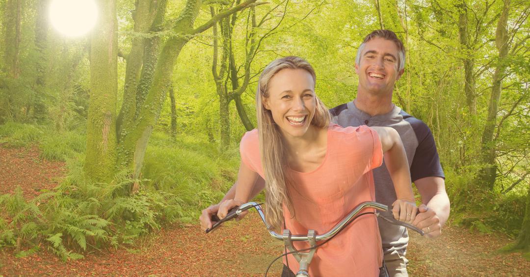 happy couple riding bicycle in forest - Free Images, Stock Photos and Pictures on Pikwizard.com