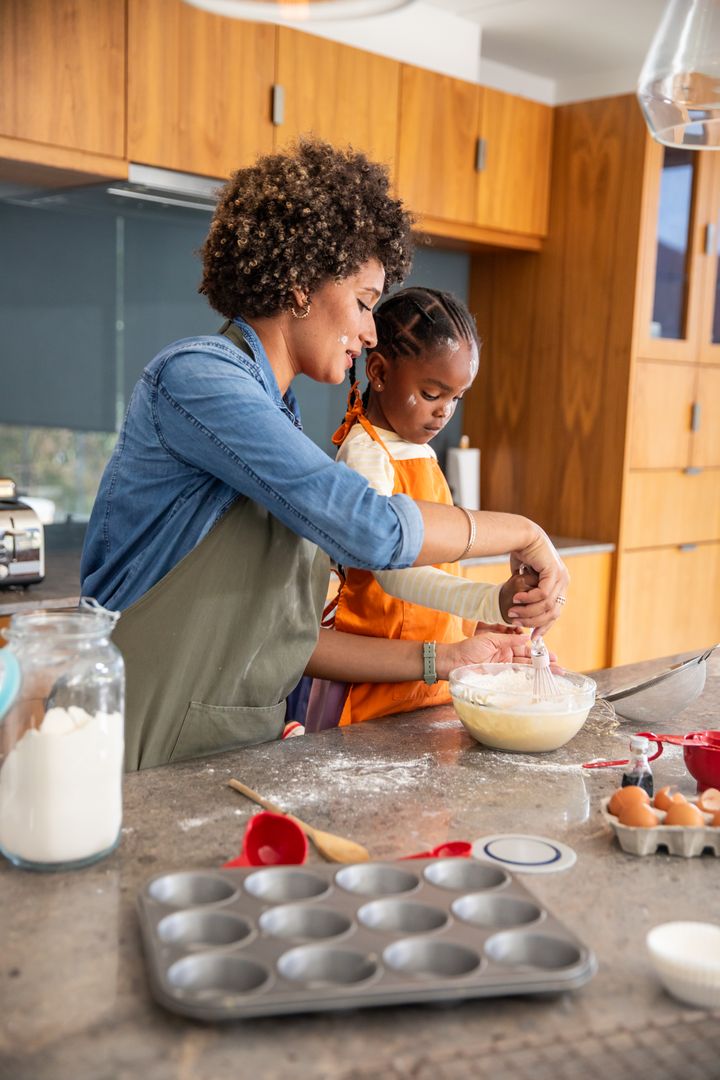 Mother and Daughter Baking Together in Cozy Culinary Setting
