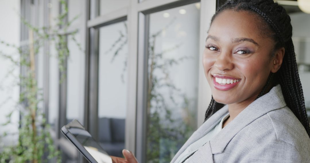 Professional Woman Smiling with Tablet in Office - Free Images, Stock Photos and Pictures on Pikwizard.com