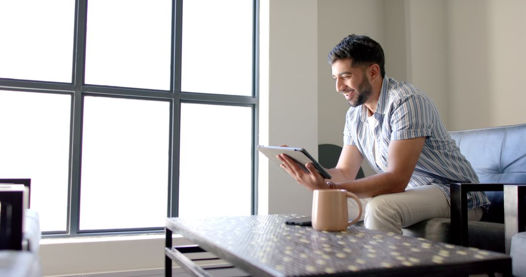 Businessman Using Tablet While Relaxing on Couch in Modern Office