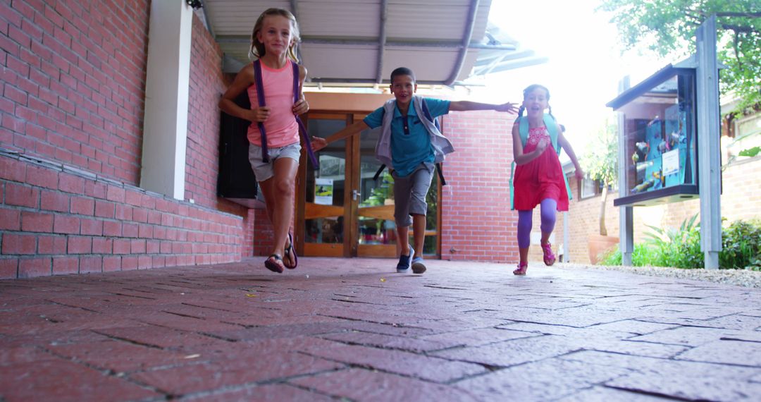 Joyful Children Running in School Hallway with Backpacks