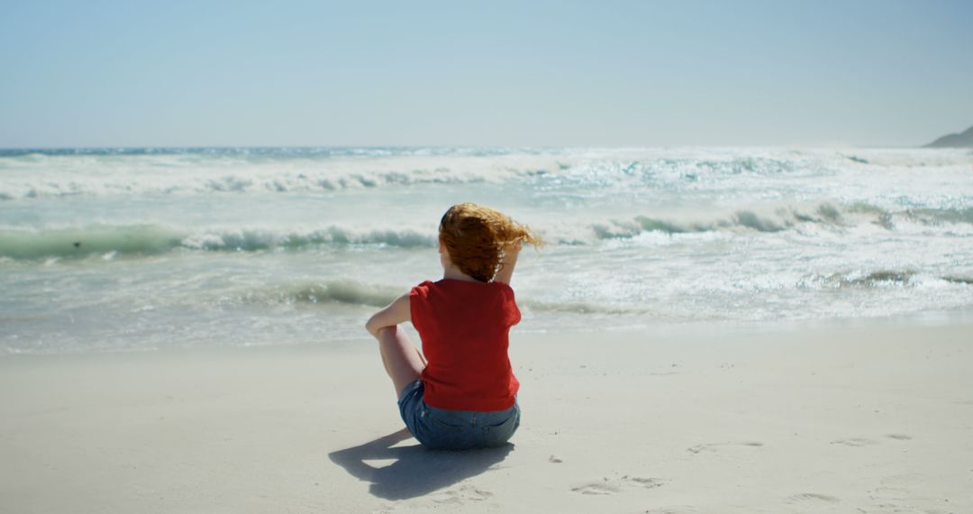 Woman Sitting on Sandy Beach with Waves Crashing in Distance - Free Images, Stock Photos and Pictures on Pikwizard.com