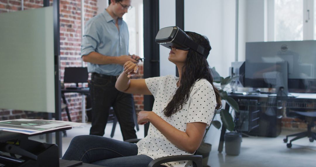 Woman Using Virtual Reality Headset While Seated at Office Desk - Free Images, Stock Photos and Pictures on Pikwizard.com