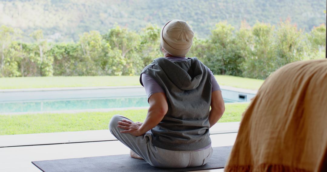 Senior Man Meditating Outdoors with Pool View, Tranquility and Relaxation