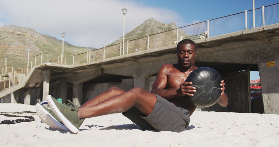 Man Exercising with Medicine Ball at Beach Side on Sunny Day - Free Images, Stock Photos and Pictures on Pikwizard.com