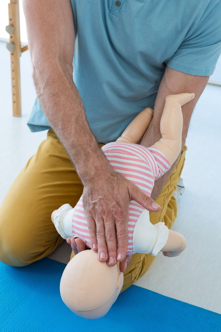 Paramedic Demonstrating Infant CPR on Dummy - Free Images, Stock Photos and Pictures on Pikwizard.com