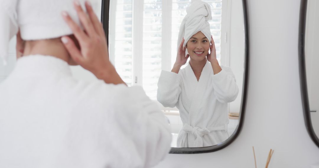 Woman in Bathrobe Looking in Bathroom Mirror Smiling with Towel Wrapped Hair - Free Images, Stock Photos and Pictures on Pikwizard.com