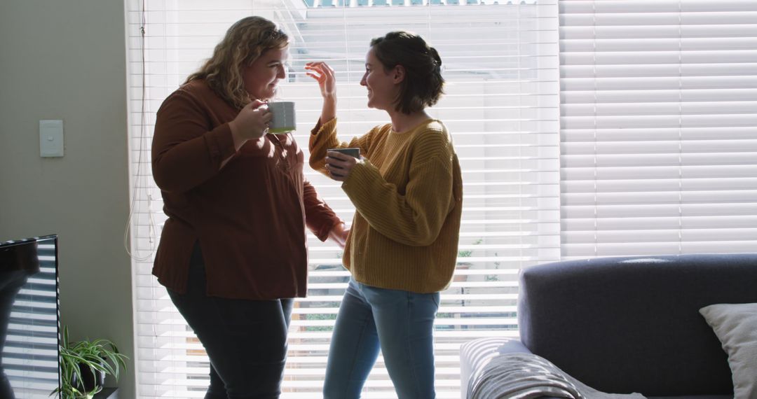 Caucasian lesbian couple embracing and drinking coffee - Free Images, Stock Photos and Pictures on Pikwizard.com