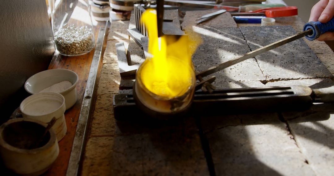 Blacksmith Holding Tongs Heating Metal in Crucible with Yellow Flame - Free Images, Stock Photos and Pictures on Pikwizard.com