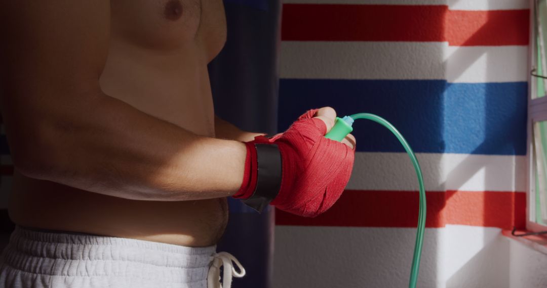 Boxer Preparing Hands with Red Wraps before Workout - Free Images, Stock Photos and Pictures on Pikwizard.com