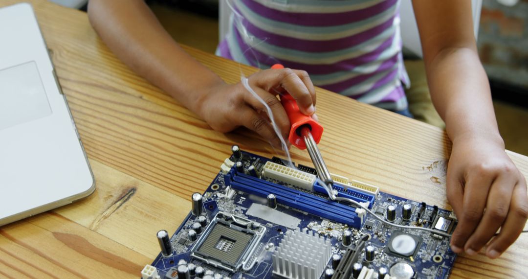 A child develops STEM skills through hands-on learning with a computer motherboard. - Free Images, Stock Photos and Pictures on Pikwizard.com