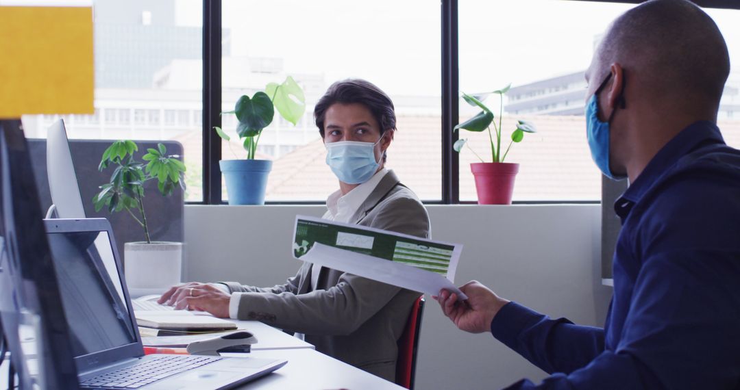 Coworkers Wearing Masks and Discussing Documents in Modern Office - Free Images, Stock Photos and Pictures on Pikwizard.com