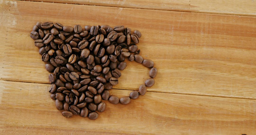 Coffee Beans Arranged in Cup Shape on Wooden Table - Free Images, Stock Photos and Pictures on Pikwizard.com