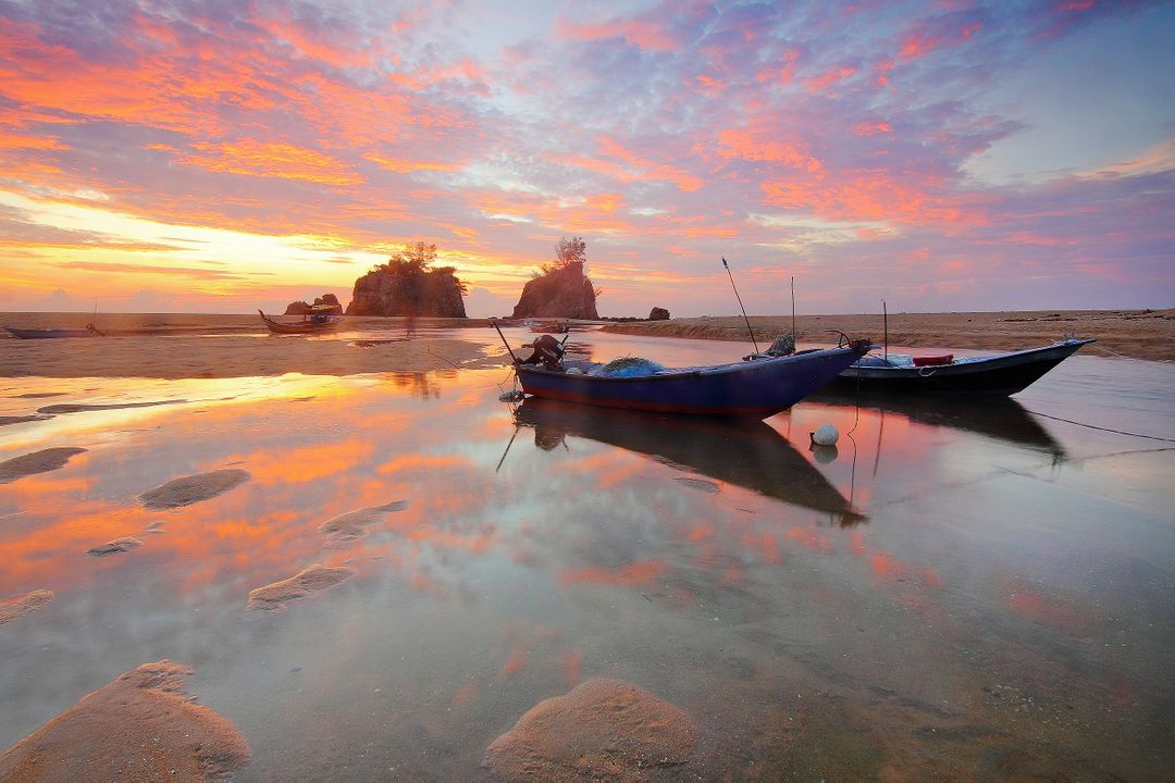 Colorful Sunset Over Tranquil Waters with Boats and Scenic Rocks - Free Images, Stock Photos and Pictures on Pikwizard.com