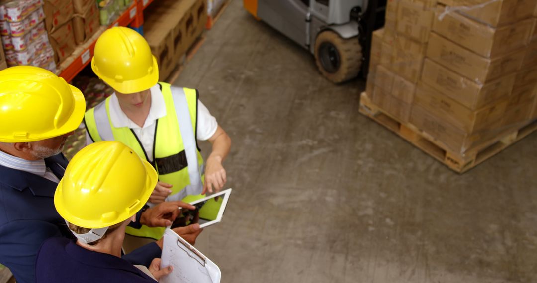 Warehouse Workers Strategizing Logistics in High Visibility Gear - Free Images, Stock Photos and Pictures on Pikwizard.com