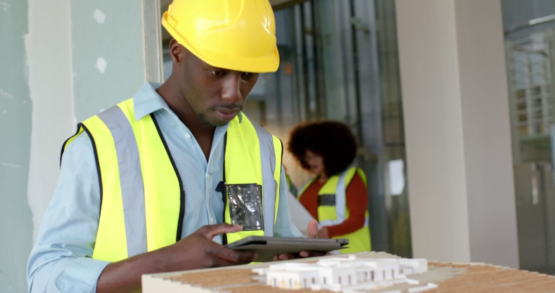 Construction Worker Using Tablet to Review Architectural Model - Free Images, Stock Photos and Pictures on Pikwizard.com