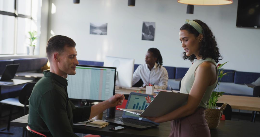 Two Colleagues Analyzing Data in Modern Co-working Space