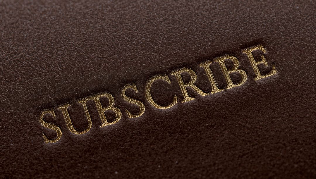 Embossed Gold Foil SUBSCRIBE on Brown Leather Texture Closeup Luxury Call to Action