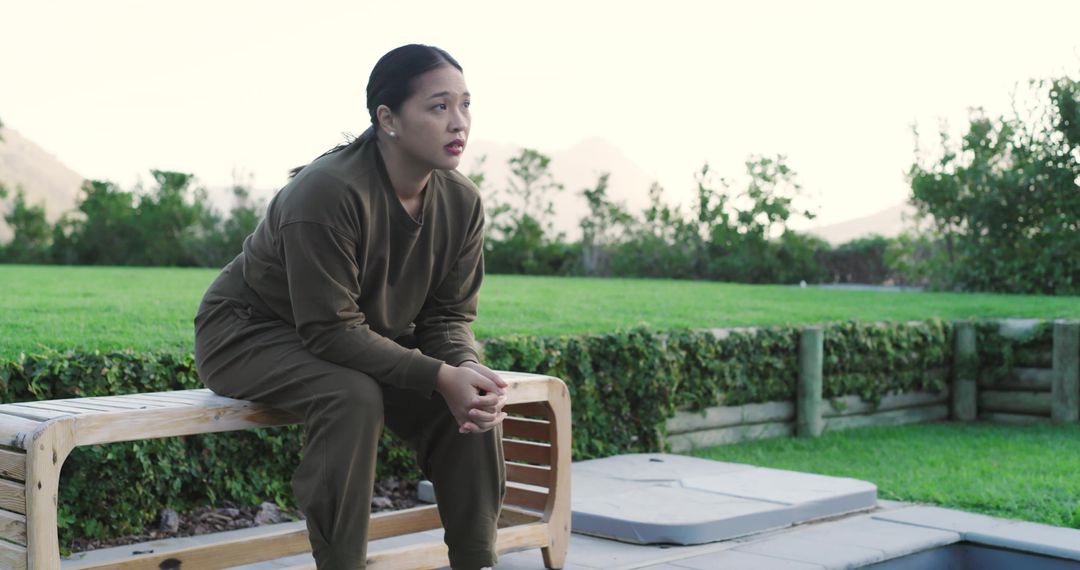 Woman Reflecting by Pool in Tranquil Garden Setting
