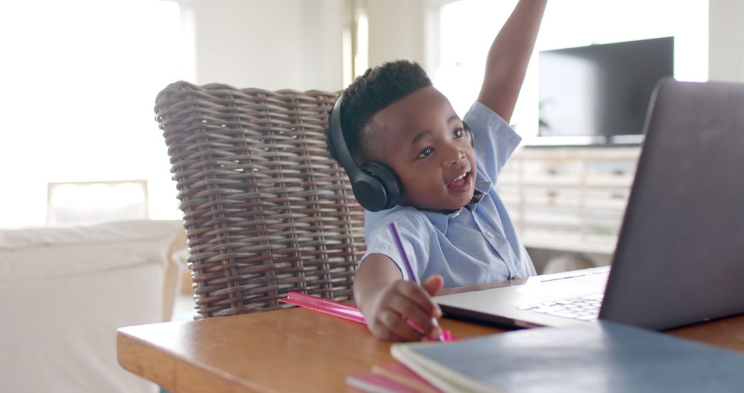 Happy african american boy with headphones learning online using laptop at home - Free Images, Stock Photos and Pictures on Pikwizard.com