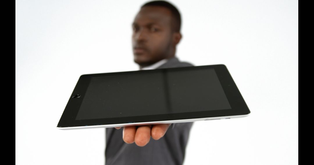 Businessman holding out tablet towards the camera - Free Images, Stock Photos and Pictures on Pikwizard.com