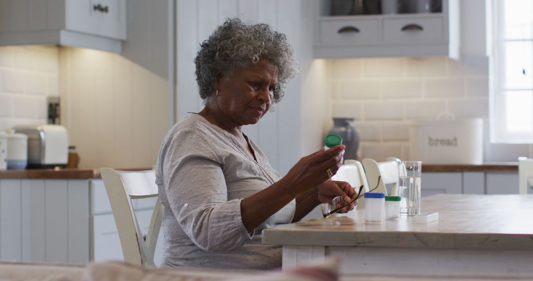 Senior Woman Taking Medication at Home in Kitchen - Free Images, Stock Photos and Pictures on Pikwizard.com