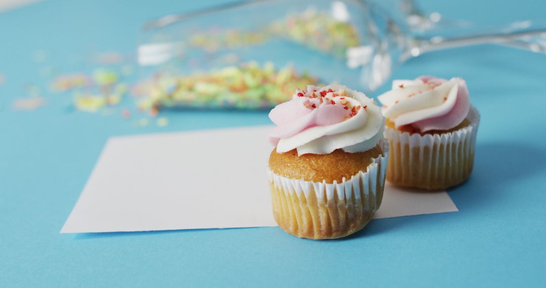 Festive cupcakes and invitations with champagne glasses and confetti
