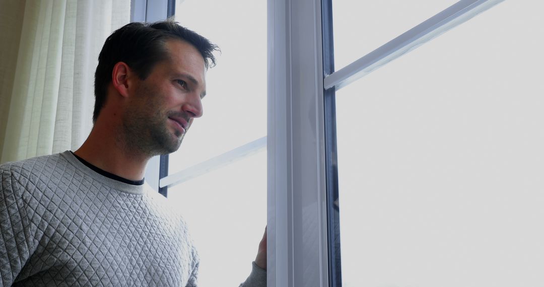 Man Looking Through Window on Overcast Day - Free Images, Stock Photos and Pictures on Pikwizard.com