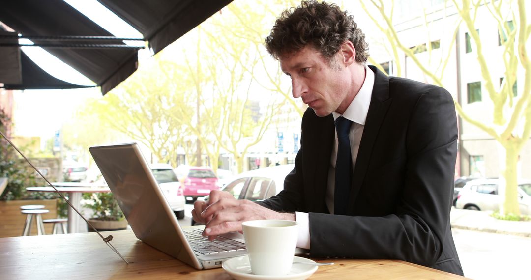 Businessman Working on Laptop at Outdoor Coffee Shop - Free Images, Stock Photos and Pictures on Pikwizard.com