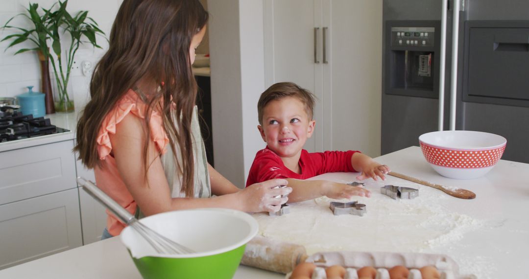 Cheerful Siblings Baking Cookies Together in Modern Kitchen