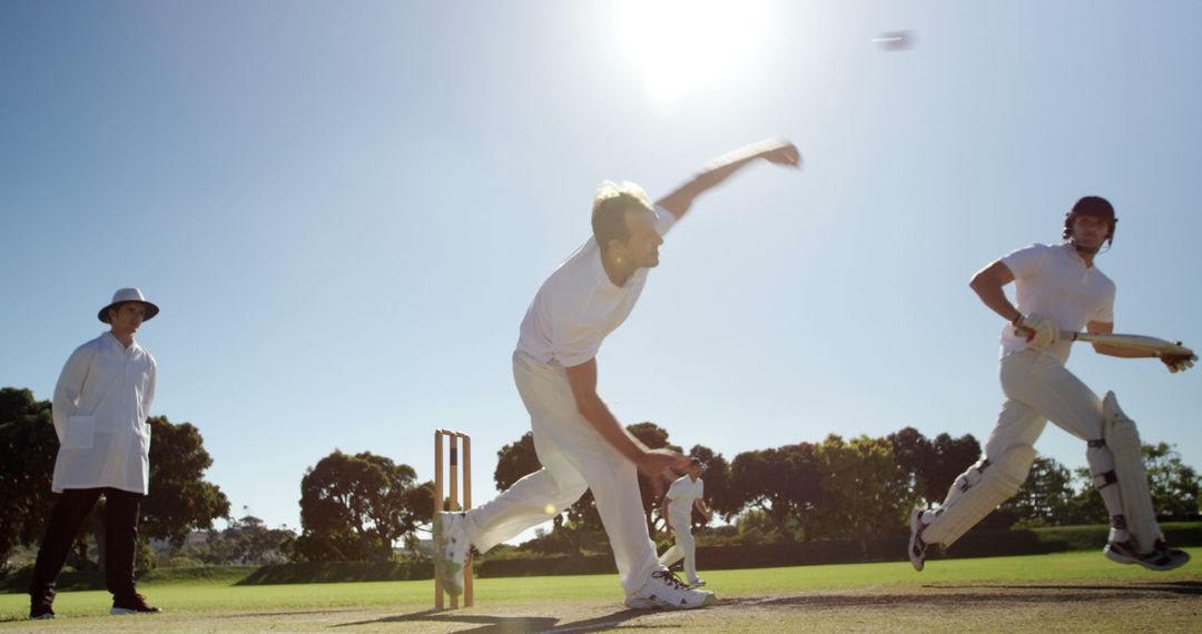 Cricket Bowler Mid-Action with Batsman and Umpire in Background - Free Images, Stock Photos and Pictures on Pikwizard.com