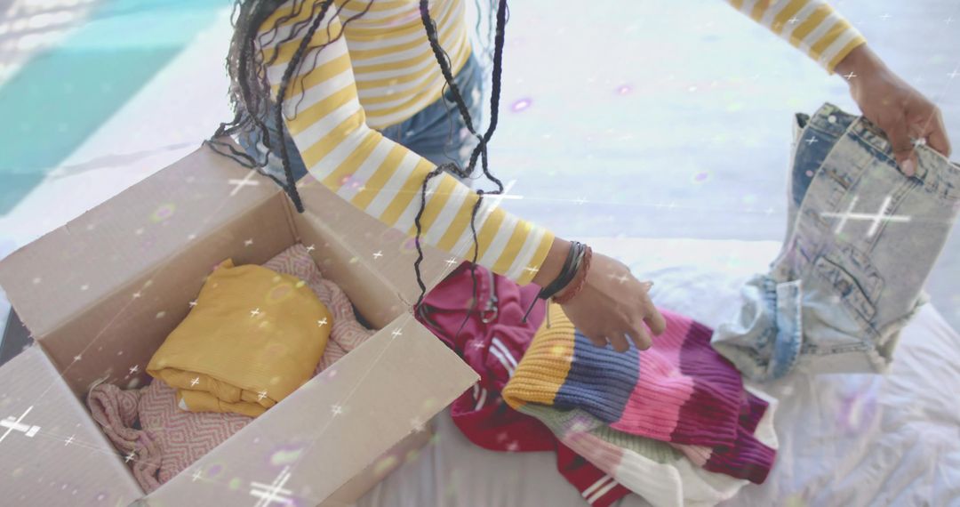 Woman Packing Clothes at Home with Cardboard Box
