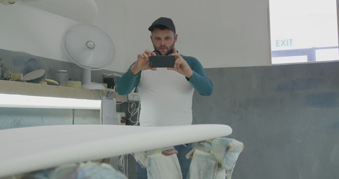 Craftsman Taking Photo of Surfboard in Workshop - Free Images, Stock Photos and Pictures on Pikwizard.com