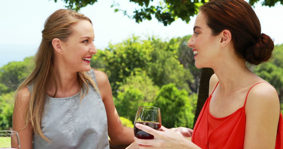 Two Women Enjoying Wine and Conversation Outdoors - Free Images, Stock Photos and Pictures on Pikwizard.com