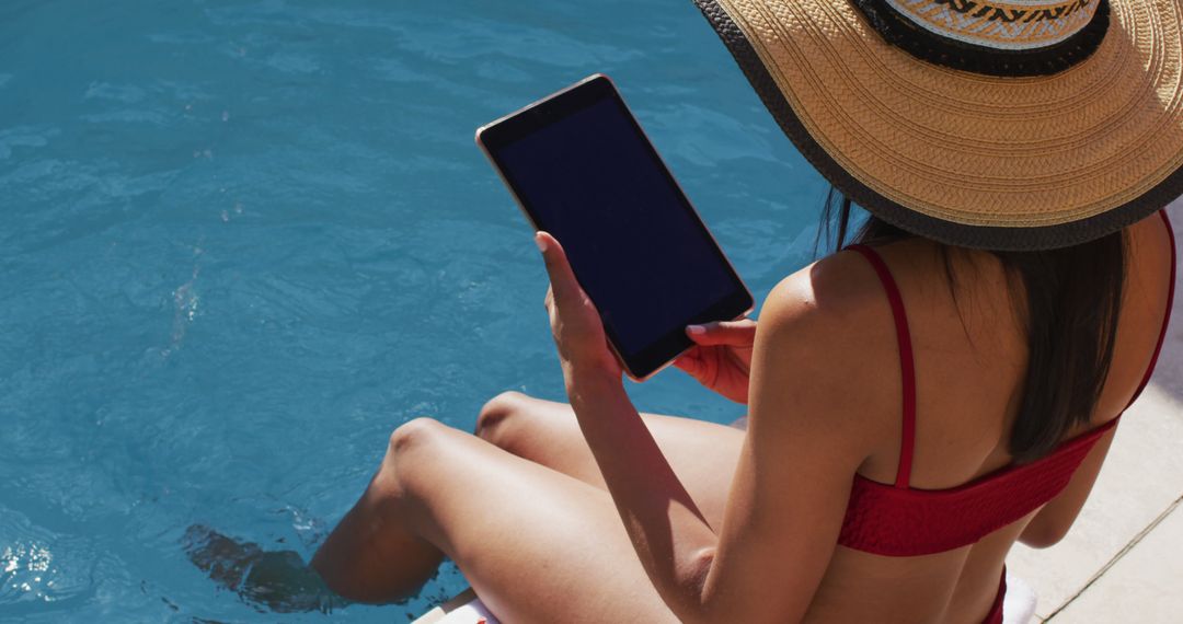 Woman Relaxing by Poolside Using Tablet on a Sunny Day - Free Images, Stock Photos and Pictures on Pikwizard.com